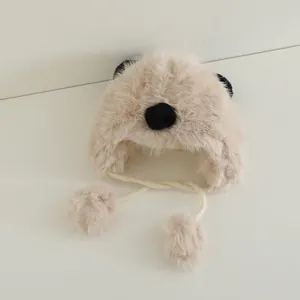 Detail of plush panda earflap hat in beige with soft faux fur and fluffy pom-pom ties