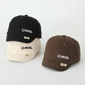 Detail of three cotton baseball caps for kids with NICE smile embroidery and soft brims