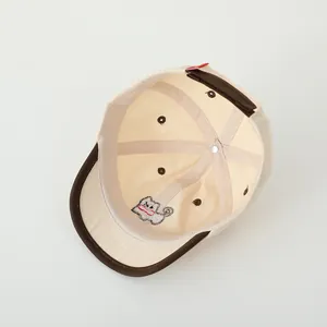 Detail of cotton baby baseball cap showing interior stitching and cartoon embroidery