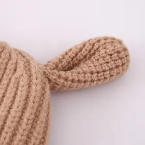 Close-up of thick khaki knit baby hat featuring cute animal ears and soft yarn texture