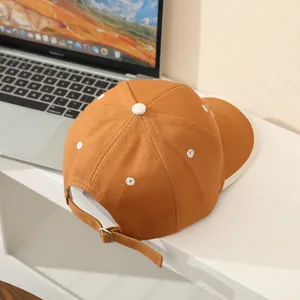 Detailed view of brown kids baseball cap featuring embroidered daisies and metal buckle