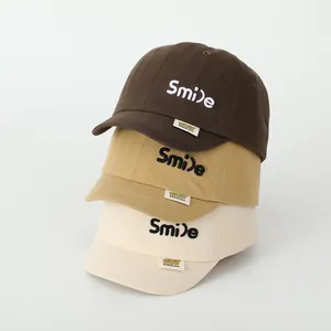 Close-up of cotton baby baseball caps with Smile embroidery and brand woven label