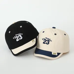 Detailed close-up of short brim baseball caps with Number 23 embroidery for kids