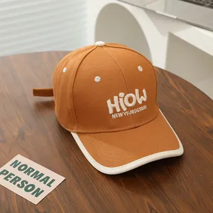 Detail of caramel cotton baseball cap with 3D white embroidery and contrast brim piping