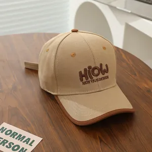 Close-up of khaki canvas baseball cap featuring brown 3D embroidery and piped brim detail
