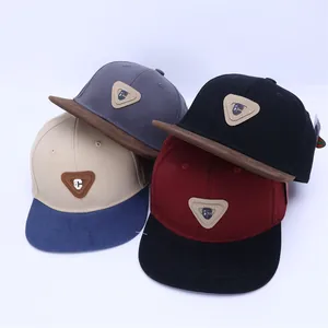Détail de quatre casquettes hip-hop à visière plate en divers coloris avec logo triangle