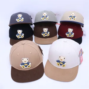 Close-up of kids cartoon bear flat brim snapback hats in diverse colorful canvas options