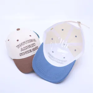 Détail d'une casquette enfant bicolore avec broderie et support de forme interne rigide