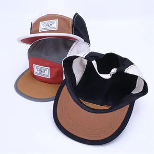 Detailansicht von drei 5-Panel-Camper-Caps mit FURBAK-Webetiketten und flachem Schirm