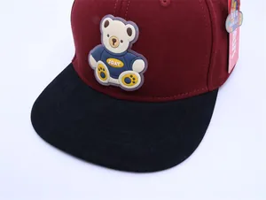 Close-up of kids' burgundy and black baseball cap with 3D bear logo and fabric texture