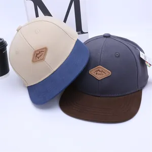 Detail of color-block baseball caps with diamond-shaped Kukuji leather brand patches