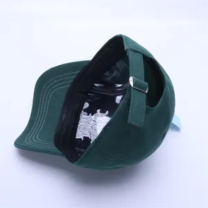 Detail view of dark green baseball cap showing metal buckle and adjustable fabric strap