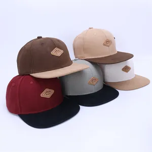 Selection of multi-colored snapback hats with mountain leather patches on canvas fabric