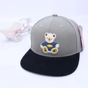 Detail of child baseball cap featuring a 3D silicone cartoon bear on grey canvas