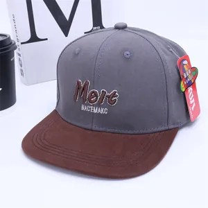 Detail of grey kids snapback cap with brown brim and Melt embroidery in lifestyle setting