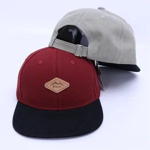 Detail view of Kukuji kids baseball caps with leather logo patch and metal buckle strap