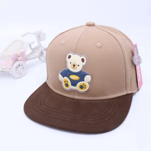 Close-up of kids hip-hop cap featuring 3D cartoon bear patch and brown flat brim