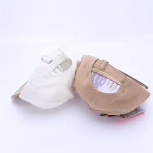 Detail view of cotton baseball caps showing metal buckles and product tags in studio light