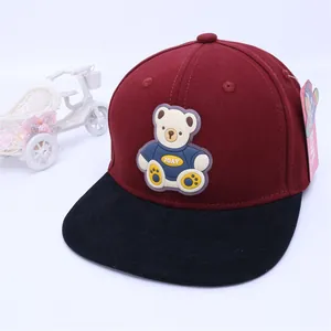 Detailed close-up of kids' baseball cap with 3D cartoon bear patch and pink butterfly tag