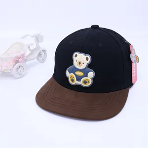 Detail of a kids baseball cap featuring a 3D cartoon bear and a pink product tag