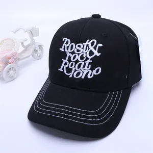 Detail of black cotton baseball cap featuring 3D white letter embroidery and contrast stitching