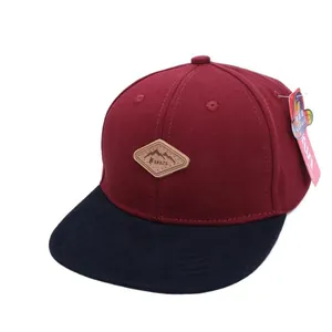 Kids baseball cap with burgundy crown, black flat brim and mountain leather patch
