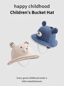 Detailed view of beige and blue toddler bucket hats with 3D bear ears and embroidery