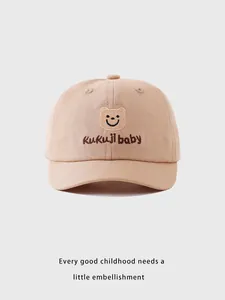 Gros plan détaillé de la casquette bébé en coton kaki avec broderie d'ourson souriant