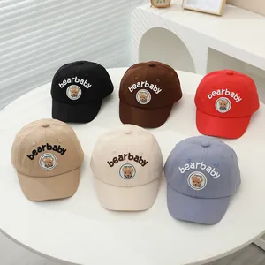 Group display of cotton baby baseball caps featuring bear patches and letter embroidery