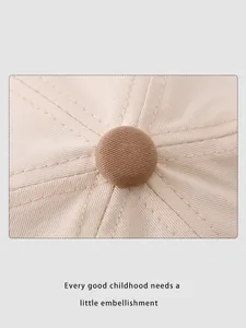 Dettaglio del tessuto in twill beige del cappellino con bottone marrone e cuciture