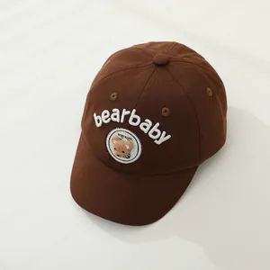 Detail of a brown cotton baseball cap for kids with bearbaby embroidery and 3D bear patch