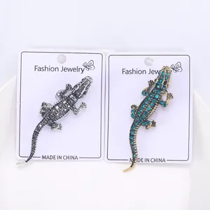 Detailed view of silver and gold crocodile brooches with sparkling rhinestone embellishments
