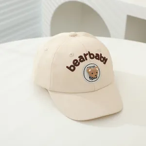 Detail of beige baby baseball cap featuring 3D bear plush and bearbaby embroidery