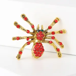 Detailed view of spider brooch with red rhinestones on vintage gold alloy base
