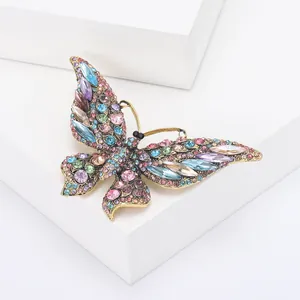 Macro-detail van vintage vlinderbroche met kleurrijke kristallen en gouden legering