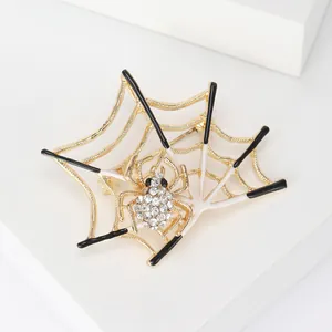 Macro detail of a golden spider web brooch featuring crystal rhinestones and enamel finish