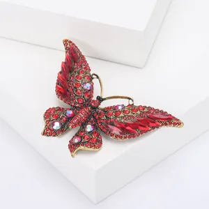 Macro detail van vintage vlinderbroche met rode strass-steentjes en AB-kristallen