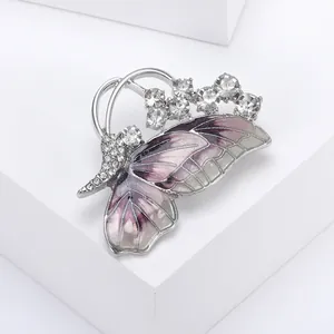 Macro view of purple gradient enamel butterfly brooch with sparkling crystals on silver base
