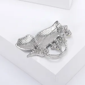 Detail of silver butterfly brooch back showing secure pin closure and textured alloy finish