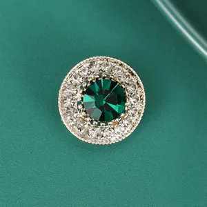Macro detail of vintage brooch featuring emerald green crystal and zircon halo