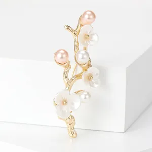 Elegant peach blossom branch brooch with pink pearls and gold finish on stone block