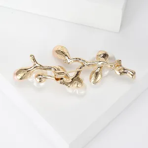 Golden peach blossom branch brooch with pearls displayed from a rear view perspective