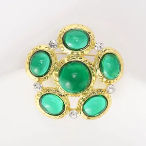 Detail of vintage palace brooch with green gemstones and sparkling white rhinestones