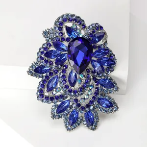 Detailed macro view of large dark blue crystal brooch with pear-cut stone on silver base