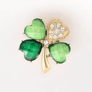 Détail d'une broche trèfle à quatre feuilles avec pétales verts et cristaux brillants