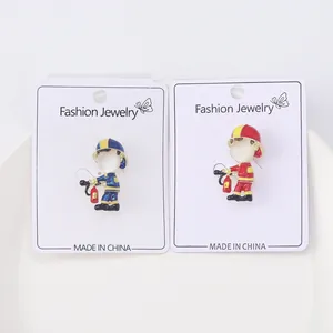 Detail of red and blue enamel cartoon firefighter brooches with pearlescent finish