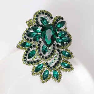 Detailed view of emerald crystal flower brooch with large green teardrop gemstone inlay