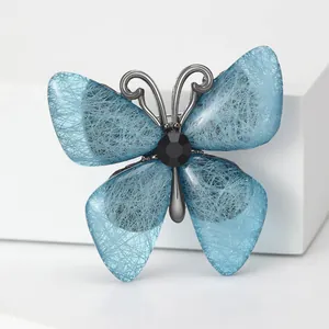 Detail of blue acrylic butterfly brooch with fiber texture and black faceted gemstone