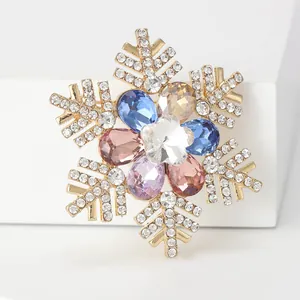 Detailed close-up of a luxury gold snowflake brooch with colorful crystal inlays