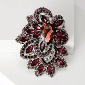 Macro view of ornate burgundy crystal brooch with teardrop stone and silver alloy base
